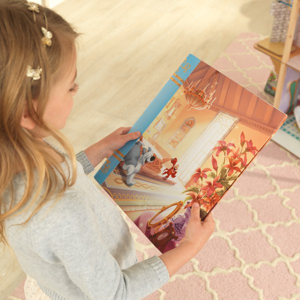 Niña contemplando el cuento que se incluye con la casa de muñecas kidkraft disney princess royal celebration 65962