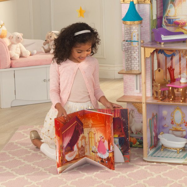Niña con cuento que incluye la casa de muñecas kidkraft disney princess royal celebration 65962